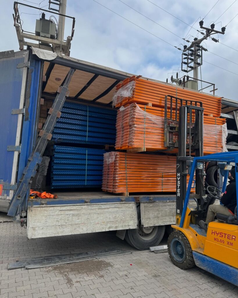 a forklift loading a truck with stacks of metal